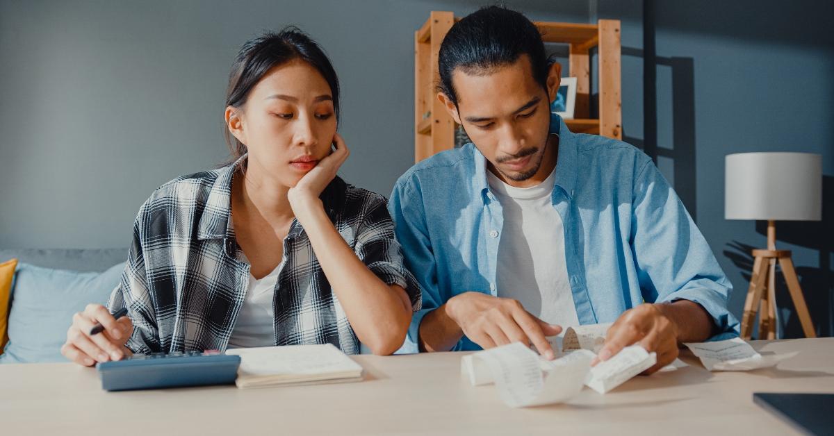 A man and woman look at bills - a couple works on their budget