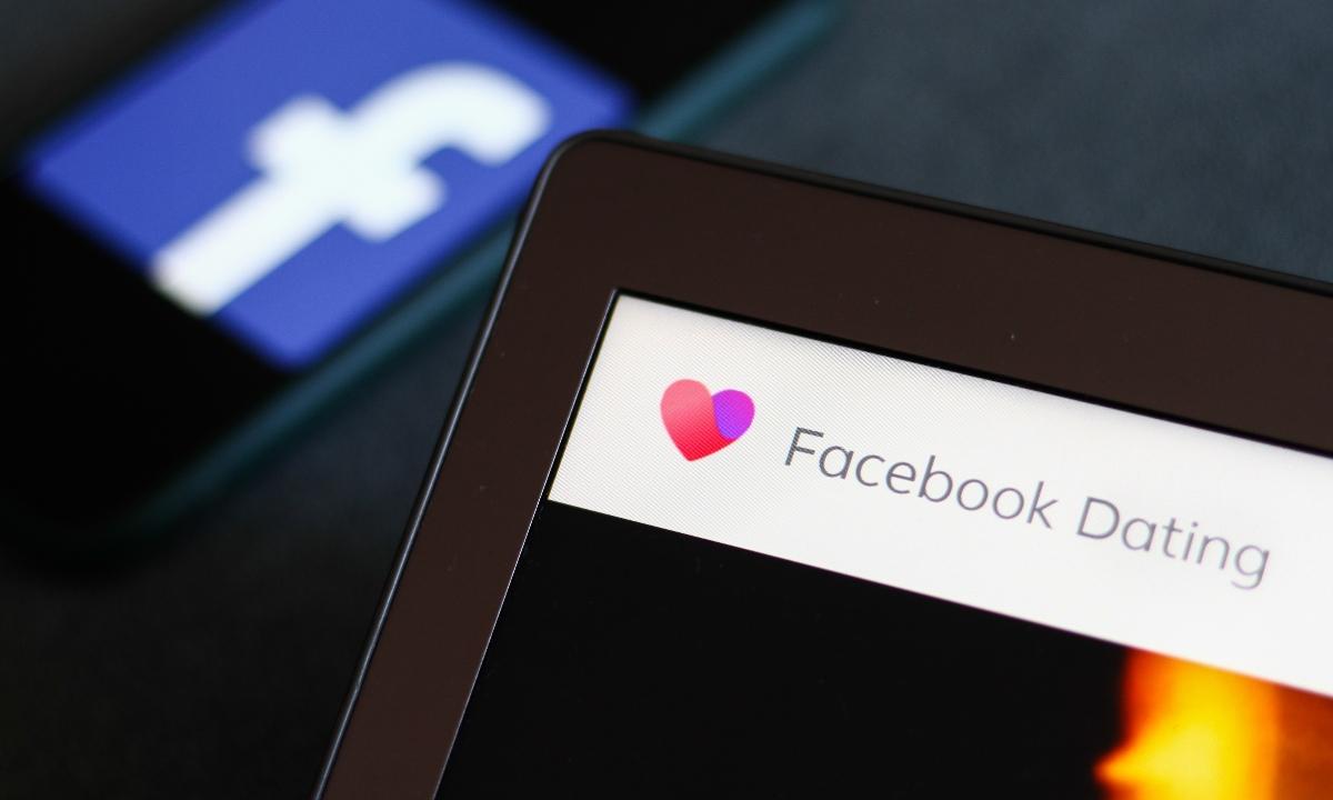 Facebook Dating App logo on a computer or tablet with the Facebook logo behind it