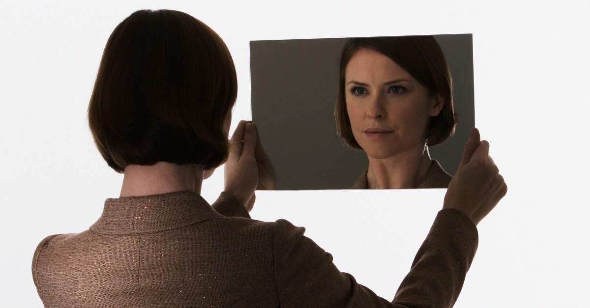 A woman holding a mirror. 