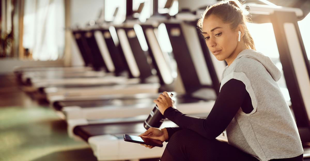 woman wearing AirPods at the gym