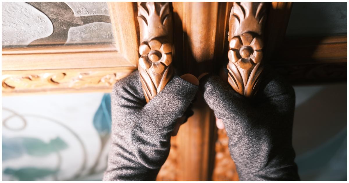 A burglar opening a door at a home