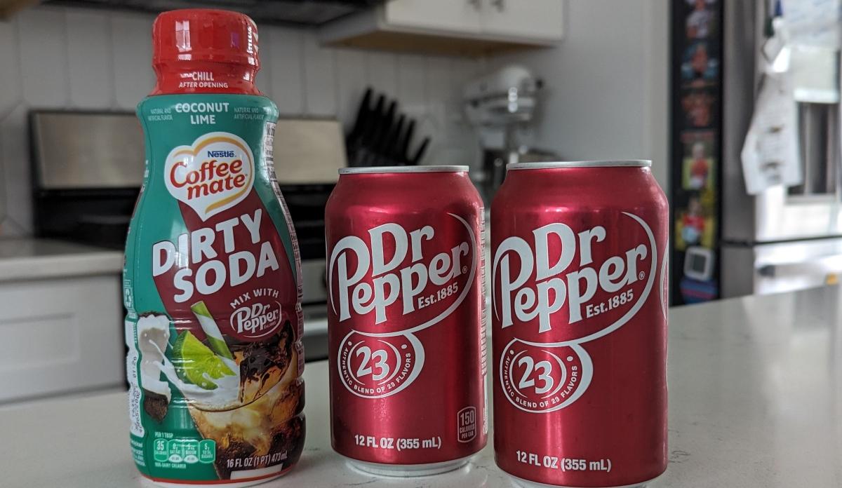 Coffee mate Dirty Soda with two cans of Dr Pepper on a kitchen counter