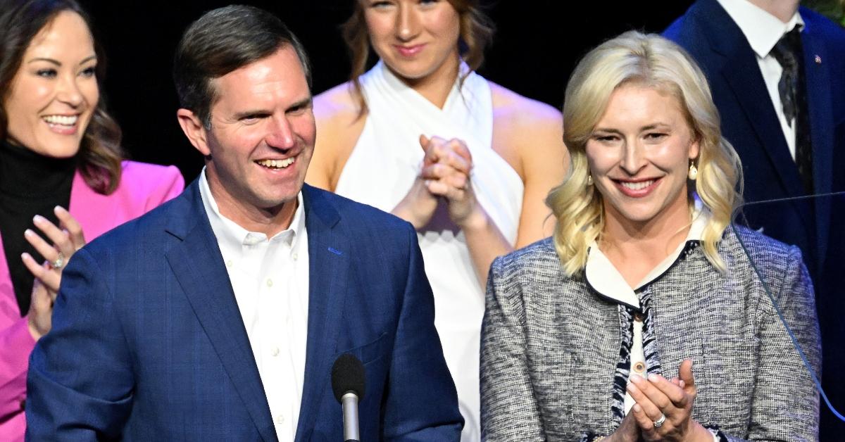 ocratic Gov. Andy Beshear is joined by his wife, Britainy Beshear (R), as he delivers his victory speech to a crowd at an election night event 