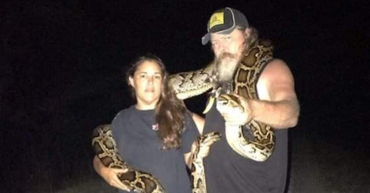 Dusty Crum and Natalee McKinney pose with a python draped across their shoulders