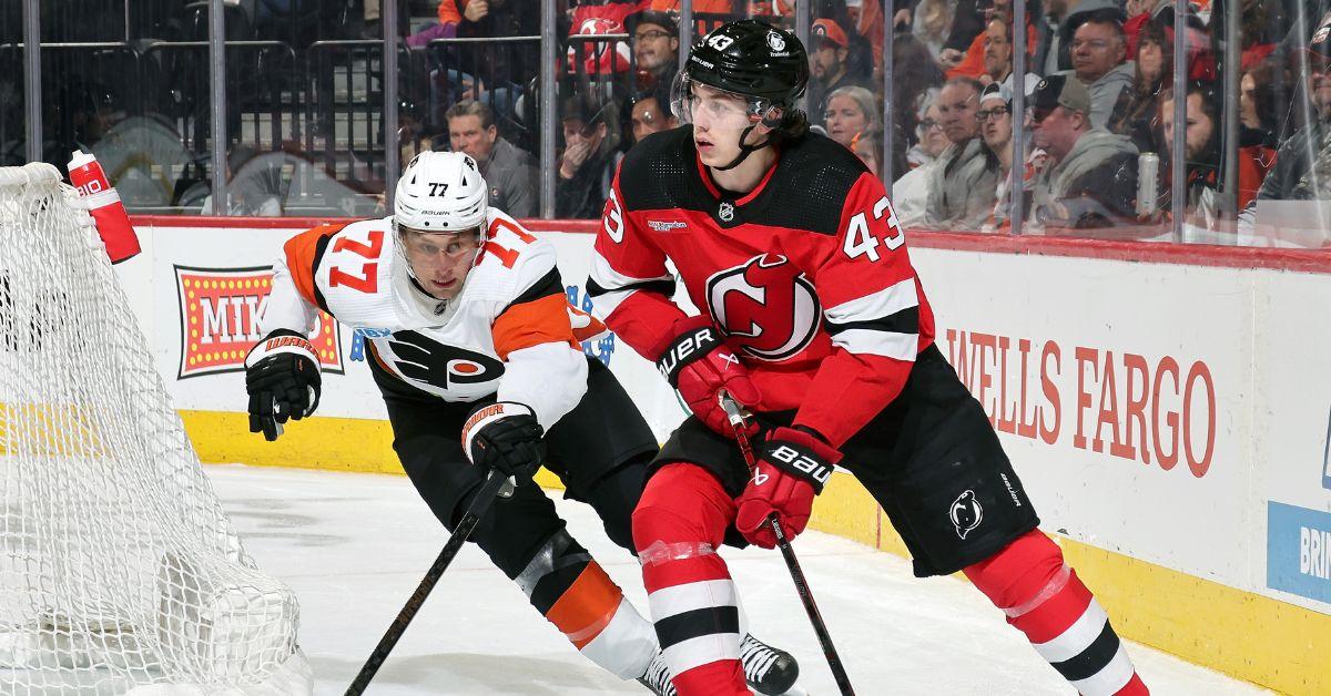 Luke Hughes #43 of the New Jersey Devils skates the puck against Erik Johnson #77 of the Philadelphia Flyers 