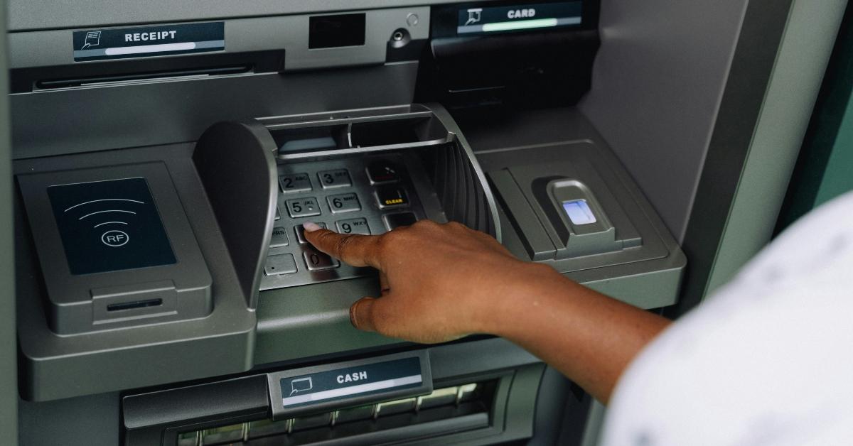 A woman uses an ATM outside.