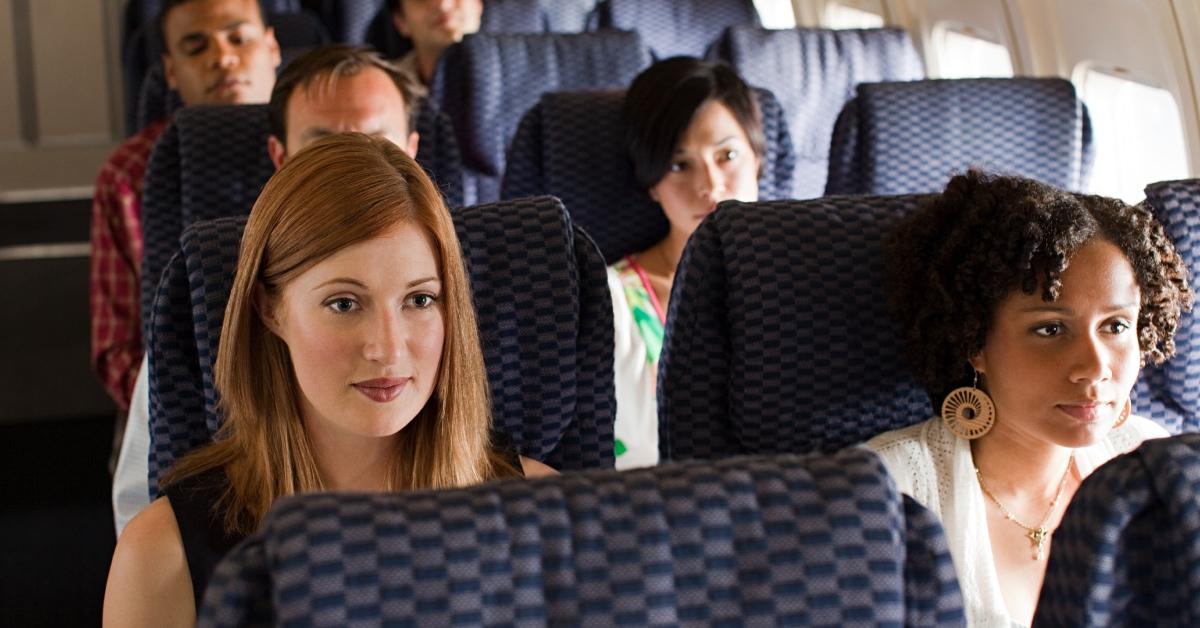 Passengers sitting in their seats on a plane.