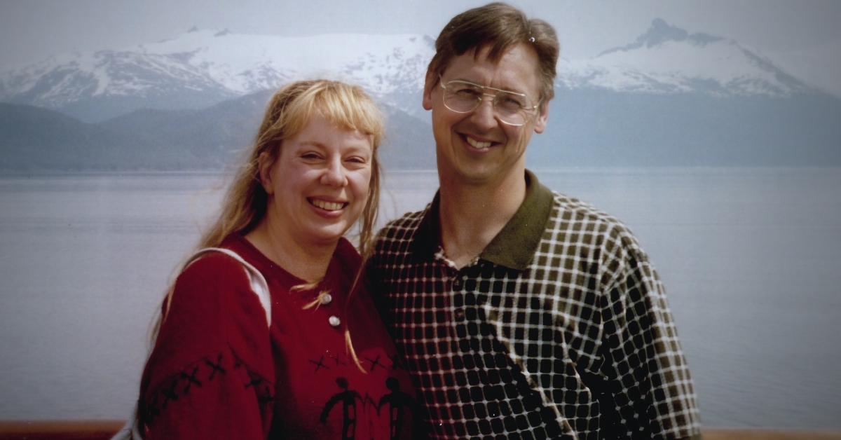 (L-R): Jana Carpenter-Koklich and Bruce Koklich smile in front of a mountain range