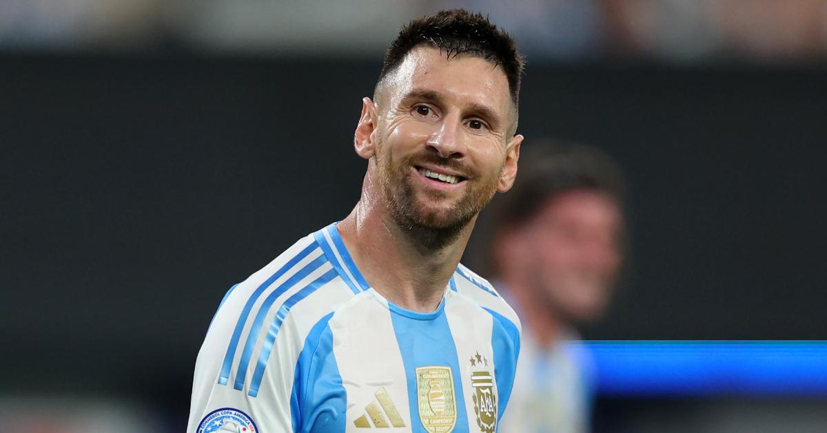 Lionel Messi smiles on the soccer field.