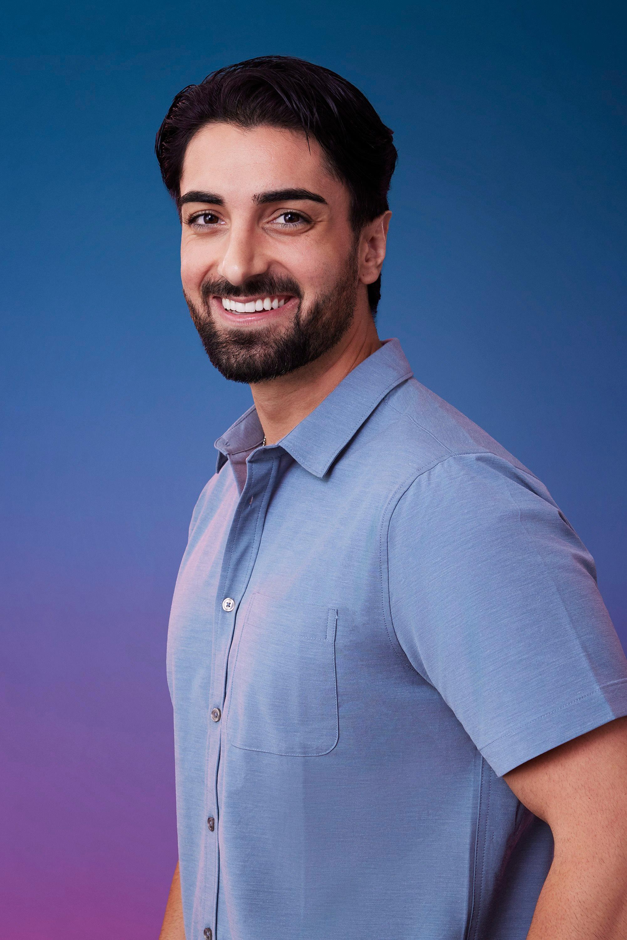 Sam N. poses in front of a blue-purple ombré background for his official 'The Bachelorette' Season 21 portrait.