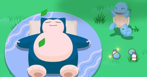 Squirtle standing next to a sleeping Snorlax.