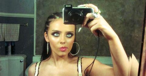 Jessie Murph taking a photo in the mirror with a camera.