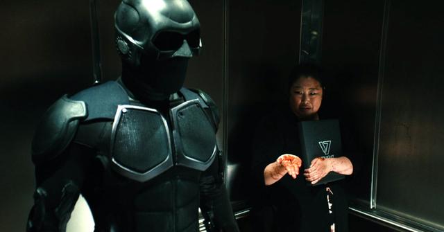 Black Noir (Nathan Mitchell) and a woman from accounting (Esther Chung)