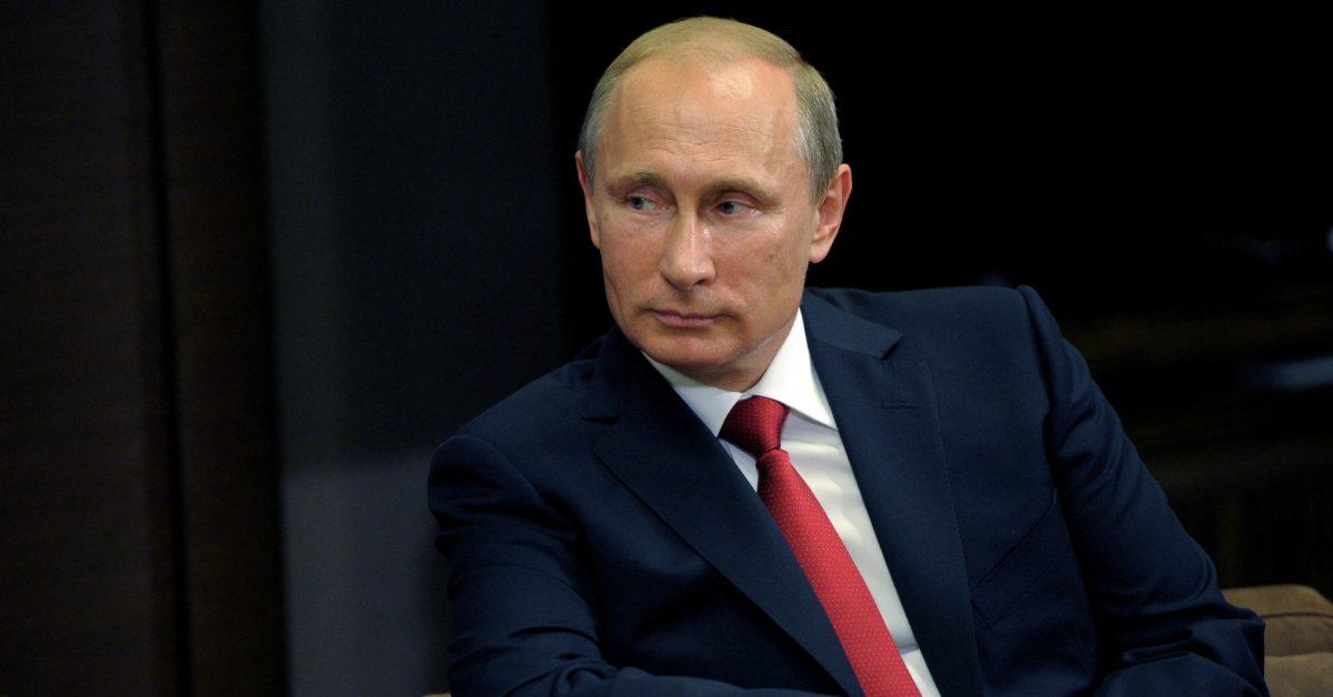 Vladimir Putin in a blue suit with a red tie.