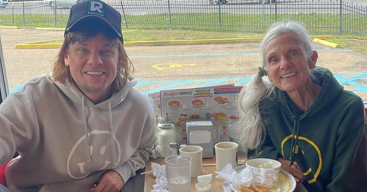 Theo Von with his mom at a table in a restaurant.