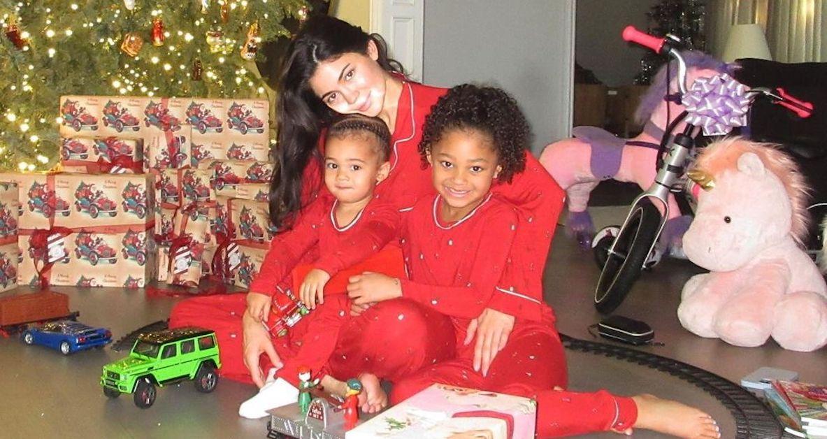 Kylie Jenner with her kids Stormi and Aire at Christmas, all wearing matching red PJs