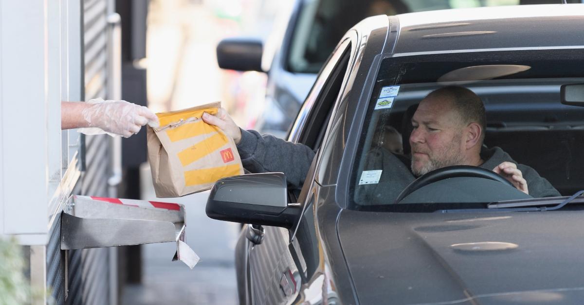 mcdonalds employee hands customer bag at the drive-thru window
