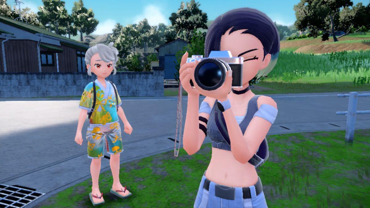 'Pokémon Scarlet & Violet' Trainer standing next to Perrin as she takes pictures.