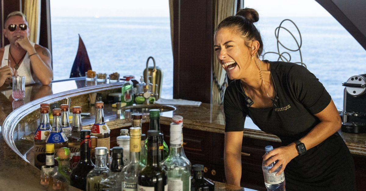 Aesha Scott laughs behind the bar while serving guests on 'Below Deck Med'