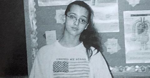 Kimberly Holton poses in front of a cork board at school