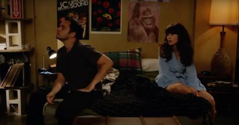 Nick and Jess sitting on a bed in a bedroom on 'New Girl'