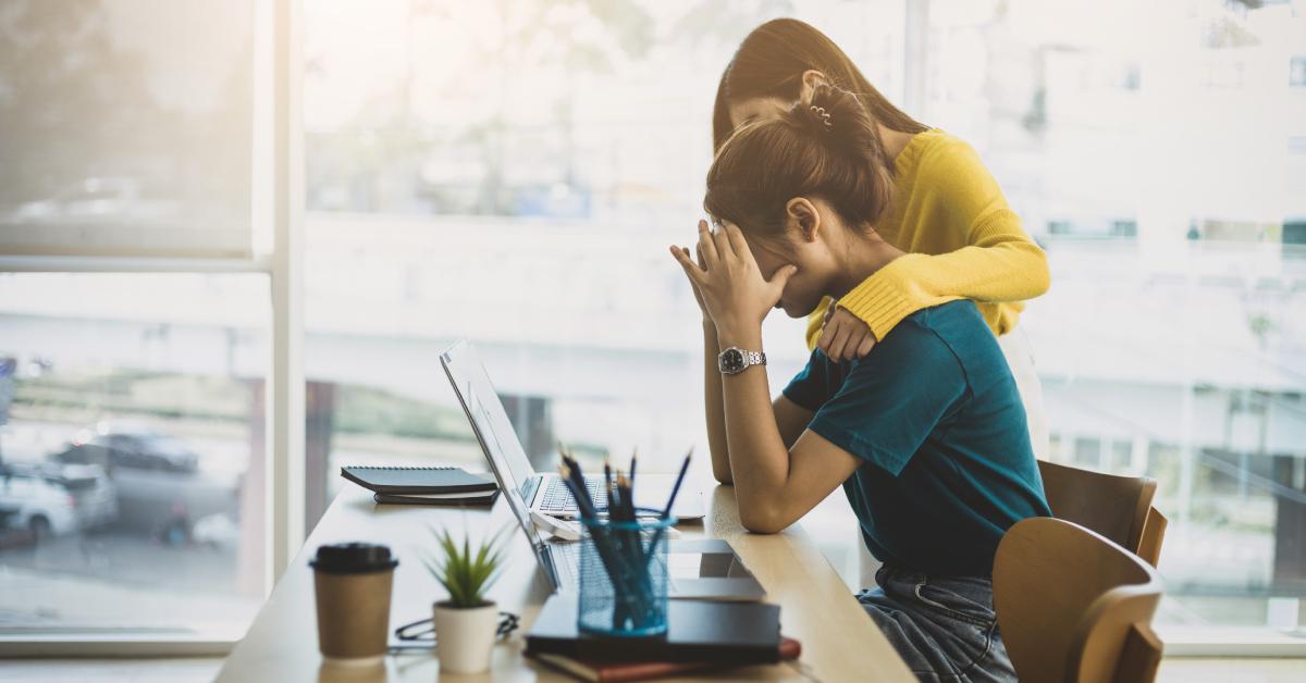 A woman comforting her stressed and discouraged colleague.