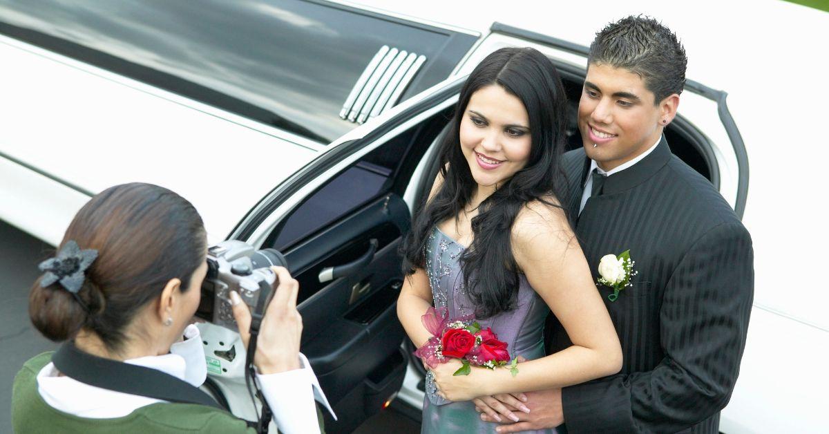 Prom dates being photographed by a mother in front of a limo