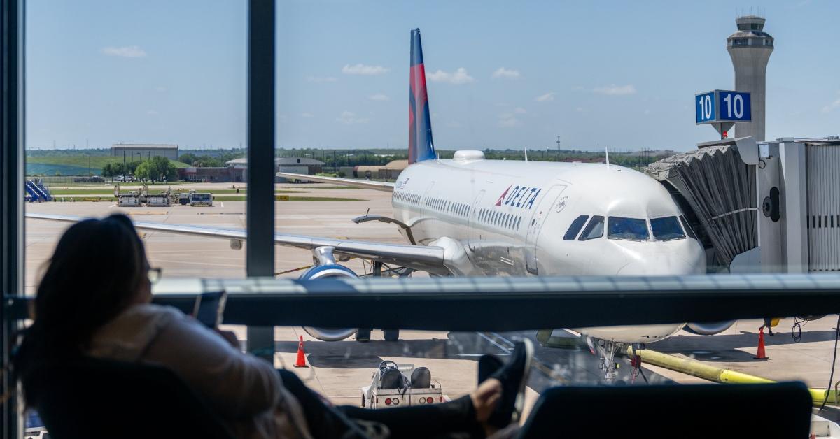  A passenger waits near a Delta Air lines terminal in the Austin-Bergstrom International Airport on April 13, 2023 in Austin, Texas.