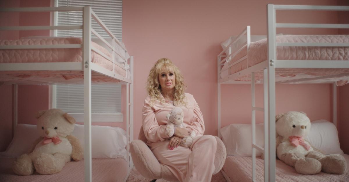 Tonia Haddix sits in a pink bedroom, clutching a stuffed monkey