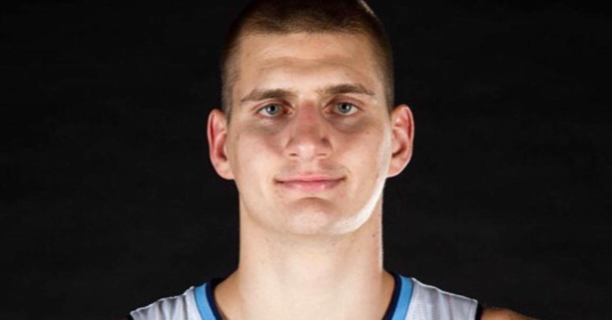 Nikola Jokić smiling in his Denver Nuggets jersey