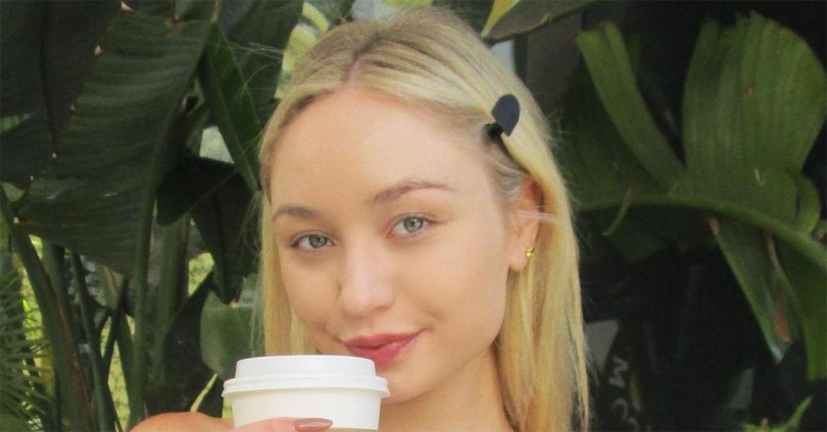 Taylor Hudson holding a coffee cup up to her mouth. 