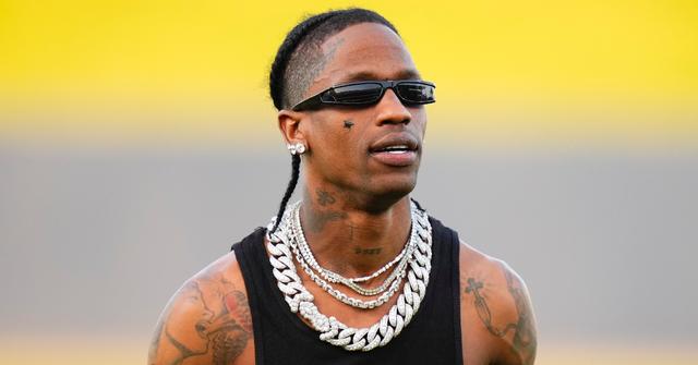 Musician Travis Scott celebrates after throwing the opening pitch.