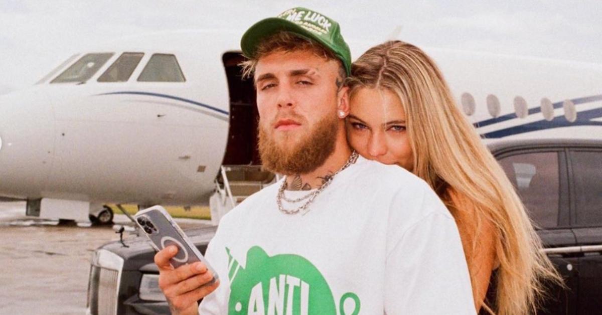 Jake Paul and Jutta Leerdam pose in front of an airplane.