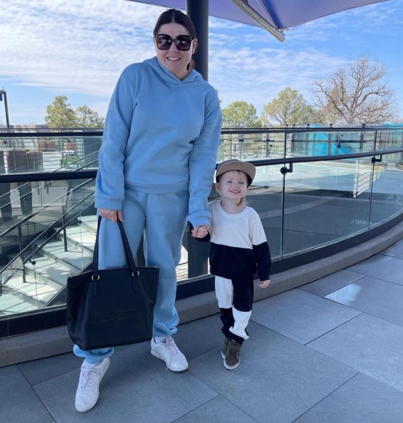 Amy Duggar with her son, Dax, on a rooftop patio