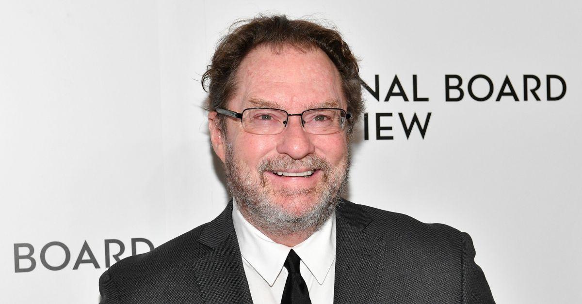 Stephen Root smiles on a red carpet