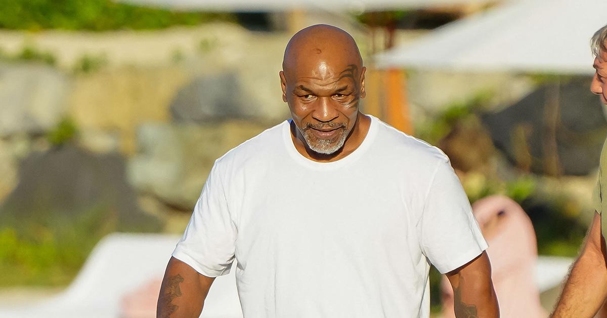 Mike Tyson in a white t-shirt on the beach. 