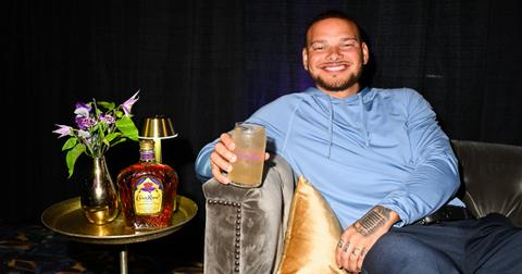 Kane Brown smiles holding a Crown Royal cocktail.