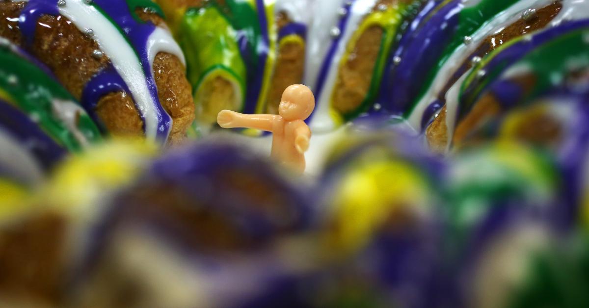 A plastic baby waits to be inserted into a fresh king cake.