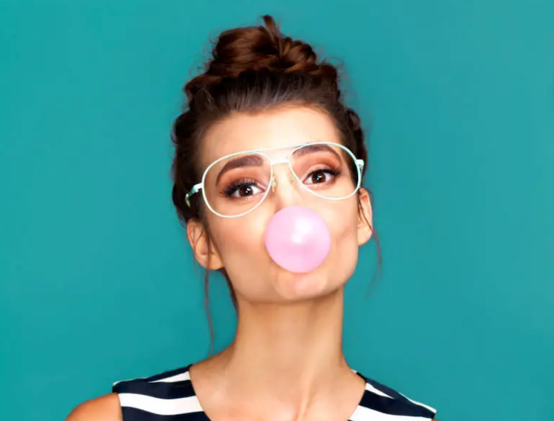 A woman blowing a bubble with gum