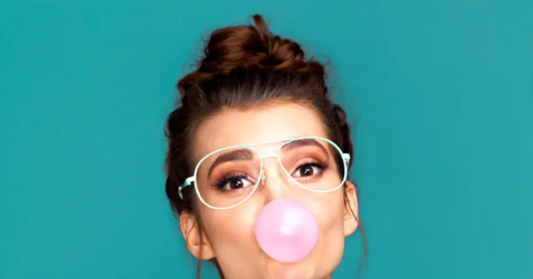A woman blowing a bubble with gum