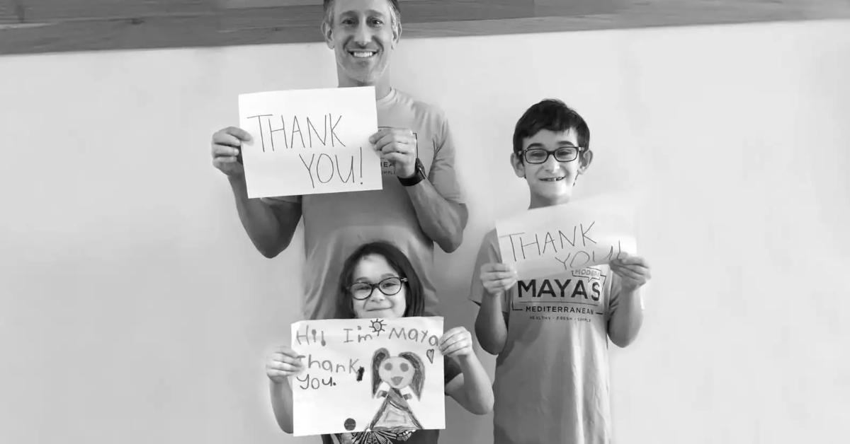 Russell with his kids, thanking their customers at Maya's Modern Mediterranean