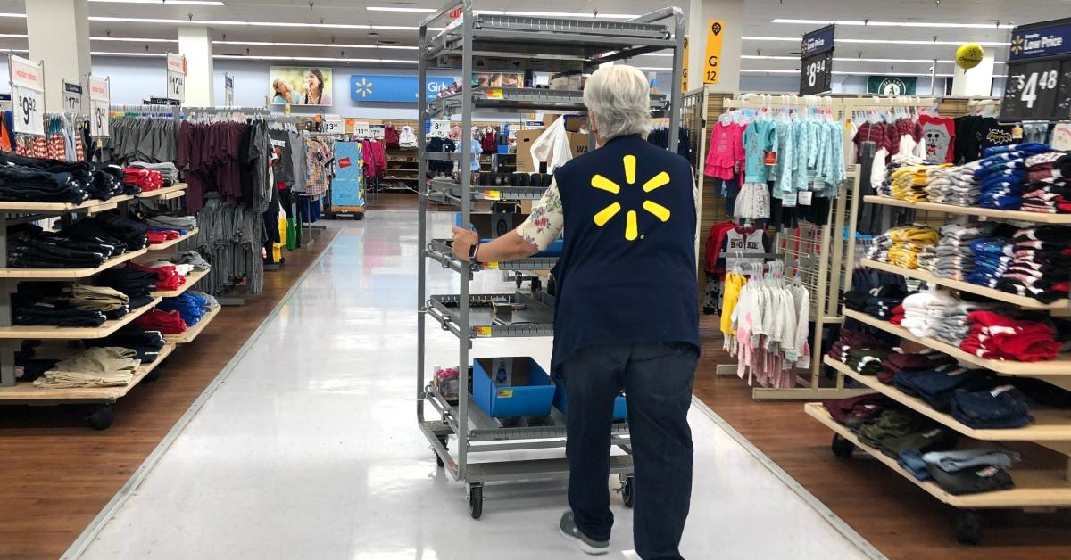 A Walmart employee pushes a cart through a Walmart store