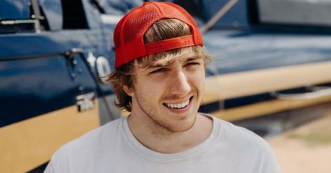 Mack Hopkins poses next to a helicopter