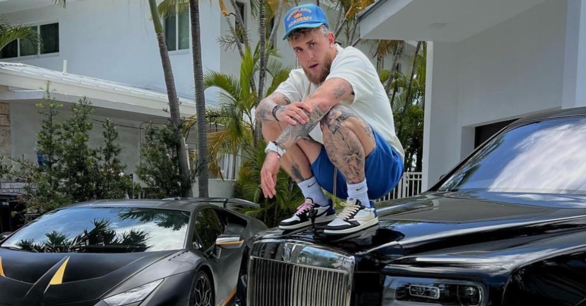 Jake Paul standing on one of his cars.