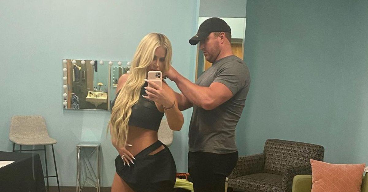 Kim Zolciak posing in a black outfit next to Kroy Biermann in a grey shirt and black pants