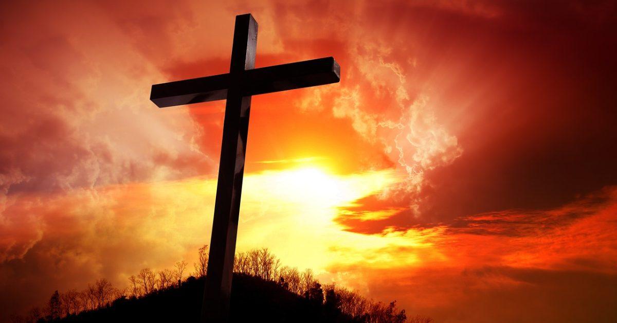A cross standing tall on a hill.