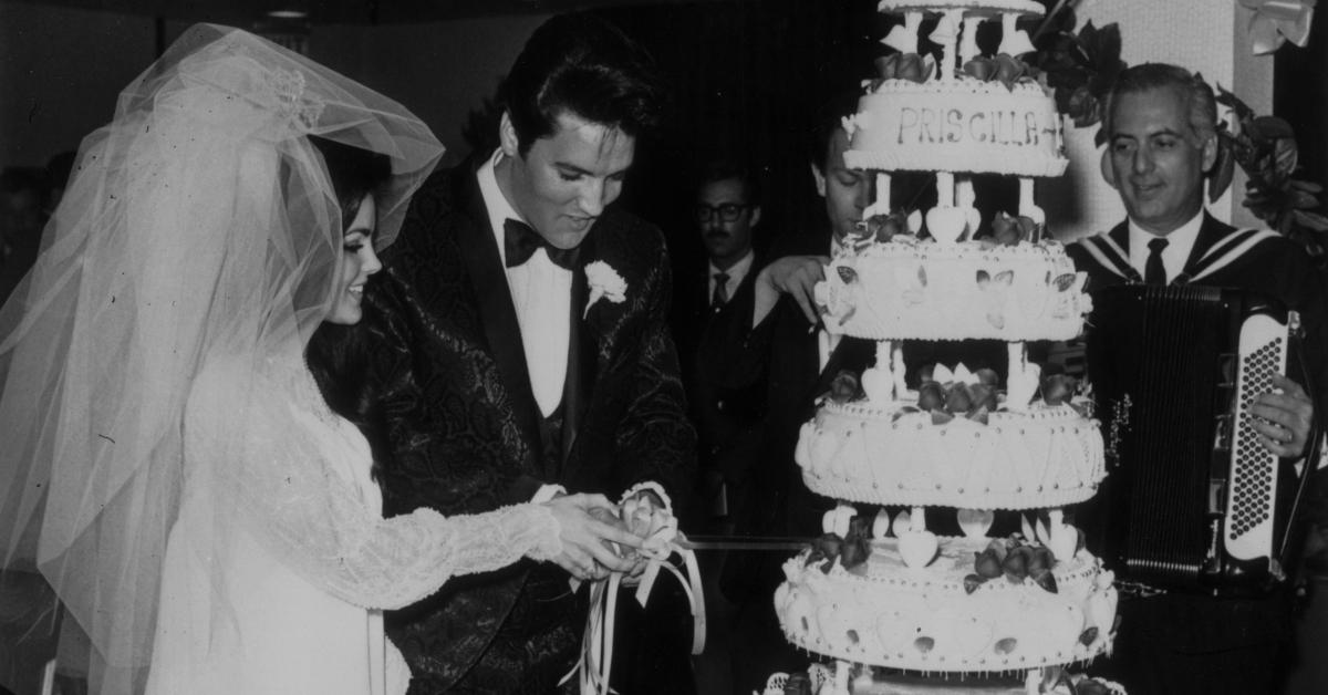 Elvis and Priscilla cutting their wedding cake.