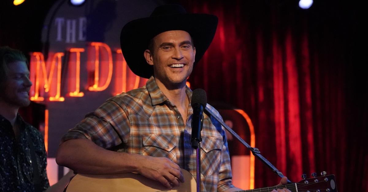  Cheyenne Jackson wearing a black cowboy hat on stage in the "Call Me a Donut Wall" season finale of 'Call Me Kat'