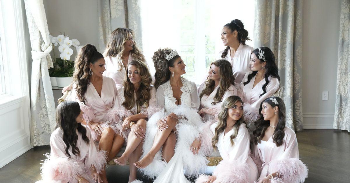 Teresa Giudice surrounded by her bridesmaids, who are looking in different directions.