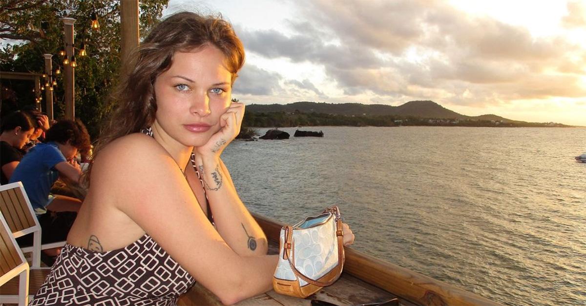 Eva Evans sitting with a hand on her chin in front of a sunset. 